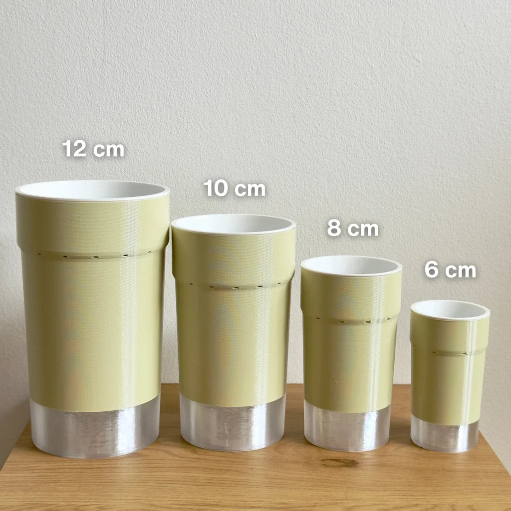Set of four 3D printed self-watering pots in 6, 8, 10, and 12 cm sizes on a wooden surface.