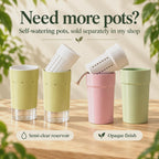 Self-watering pots shown in two finishes: pistachio pots with semi-clear bottom reservoirs, and pink and green pots with opaque bodies. Angled white slotted inner pots reveal the removable inserts, including a beige wick. Available separately in the shop.